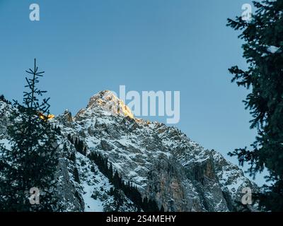 Blick auf einen Berggipfel, beleuchtet von der Abendsonne. Schönes klares Winterwetter in den Bergen Stockfoto