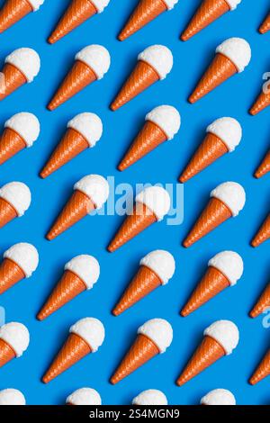 Lebendiges Muster aus Kunststoff-Eiskegel auf blauem Hintergrund, symbolisiert Kritik an Junk Food und künstlicher Diät-Kultur Highlights Umwelt Stockfoto