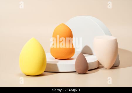 Eine Vielzahl von farbenfrohen Kosmetikschwämmen in verschiedenen Formen und Größen auf hellem Hintergrund, entwickelt für Make-up-Anwendung und Blenden, die V Stockfoto