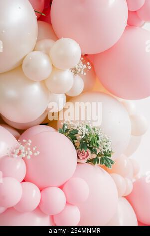 Ballon-Arrangement in Rosa und weiß mit zarten floralen Akzenten. Stockfoto