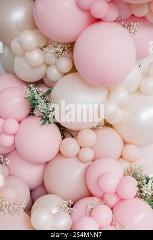 Ballon-Arrangement in Rosa und weiß mit zarten floralen Akzenten. Stockfoto