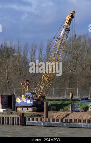 Kœnigsmacker, Frankreich - Blick auf einen Raupenkran Kobelco 7035 für Stapelarbeiten auf einer Baustelle am Ufer der Mosel. Stockfoto