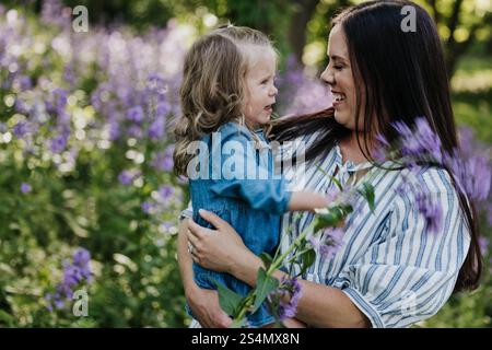 Mutter und Tochter stehen zusammen im Feld der Wildblumen Stockfoto
