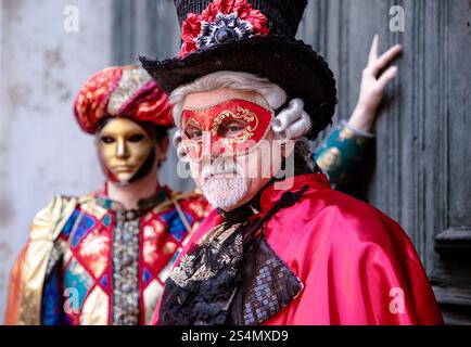 Reife kaukasische Männer in venezianischen Kostümen mit Masken auf einer Elega Stockfoto
