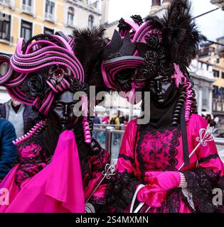 Raffinierte venezianische Karnevalskostüme mit rosa und schwarzen Federn Stockfoto