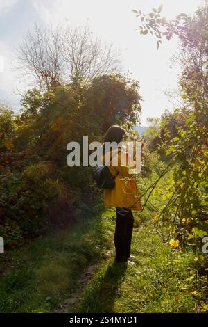 Gelbe Jacke und Technik: Frau mit Telefon im Wald Stockfoto
