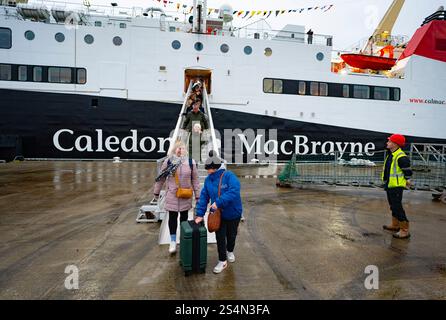 Troon, Schottland, Großbritannien. Januar 2025. Die viel verspätete und überteuerte Passagierfähre MV Glen Sannox macht ihre erste planmäßige Überfahrt zwischen Troon und Brodick auf der Isle of Arran. Die kaledonische MacBrayne-Fähre ist sieben Jahre zu spät und viele Millionen Pfund über dem Budget. {BILD . Passagiere aus Arran steigen in Troon aus. Iain Masterton/Alamy Live News Stockfoto