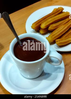 Schokolade mit Churros. Spanische Churros mit Schokoladensoße. Tasse heiße Schokolade. Typisch spanisches Essen Stockfoto