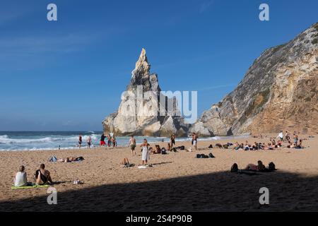 Die Menschen entspannen sich am Strand Praia da Ursa in Portugal, dem abgeschiedenen Sandstrand am Atlantischen Ozean mit malerischen Felsformationen auf dem westlichsten Festland der EU Stockfoto