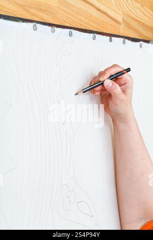 Künstler zeichnet Skizze mit Bleistift auf Seide für kalte Batikmalerei Stockfoto
