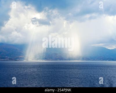 Strahlen der Sonne bricht durch die Wolken in der Nähe von Küste von Kalabrien, Italien Küste in Straße von Messina Stockfoto