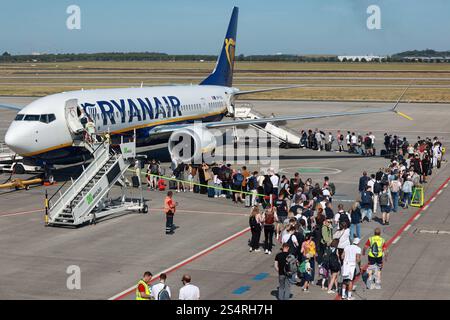 02.09.2024, Schönefeld, Brandenburg, DE - Reisende steigen am Flughafen BER in eine Maschine der Fluggesellschaft Ryanair ein. Airline, Airport, Alltag, Aussen, Aussenaufnahme, Billigflieger, Billigfluggesellschaft, boarden, Boeing, Boeing, Brand, Brandenburg, deutsch, Deutschland, einsteigen, Einstieg, Europa, europaeisch, Ferien, Fernreise, Fliegen, Flieger, Flug, Fluggaeste, Fluggesellschaft, Flughafen, Fluglinie, Flugpassagiere, Flugreise, Flugtechnik, Flugverkehr, Flugzeug, Gesellschaft, Jahreszeit, Kaukasier, kaukasisch, Luftfahrtgesellschaft, Luftfahrtunternehmen, Luftverkehr, Mensc Stockfoto