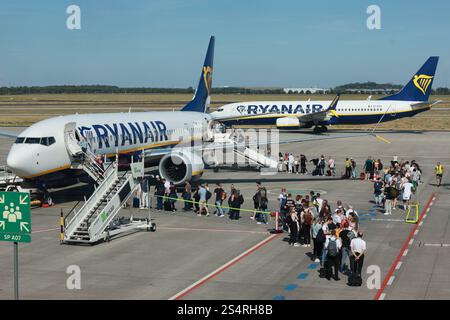 02.09.2024, Schönefeld, Brandenburg, DE - Reisende steigen am Flughafen BER in eine Maschine der Fluggesellschaft Ryanair ein. Airline, Airport, Alltag, Aussen, Aussenaufnahme, Billigflieger, Billigfluggesellschaft, boarden, Boeing, Boeing, Brand, Brandenburg, deutsch, Deutschland, einsteigen, Einstieg, Europa, europaeisch, Ferien, Fernreise, Fliegen, Flieger, Flug, Fluggaeste, Fluggesellschaft, Flughafen, Fluglinie, Flugpassagiere, Flugreise, Flugtechnik, Flugverkehr, Flugzeug, Gesellschaft, Jahreszeit, Kaukasier, kaukasisch, Luftfahrtgesellschaft, Luftfahrtunternehmen, Luftverkehr, Mensc Stockfoto