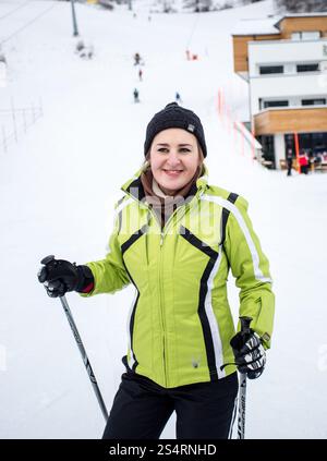 Closeup Portrait von süß lächelnd Skifahrerin auf die Abfahrt der Skipiste Stockfoto