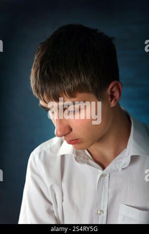 Trauriges junger Mann Porträt auf dem dunklen Hintergrund Stockfoto