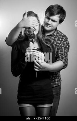 Schwarz / weiß Porträt des jungen Mannes für Freundinnen Augen für Überraschung Stockfoto