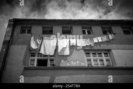 Schwarz / weiß Foto Kleidung trocknen auf der Wäscheleine außerhalb Grunge Gebäude Stockfoto