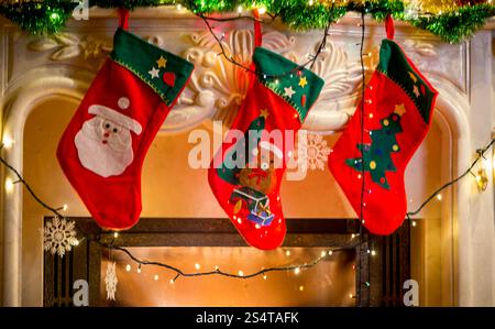 Drei rote Weihnachtsstrümpfe verzierten Kamin hängen Stockfoto