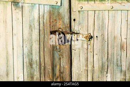 Nahaufnahme Foto Metall der alten Schleuse hängen hölzerne Scheunentor Stockfoto