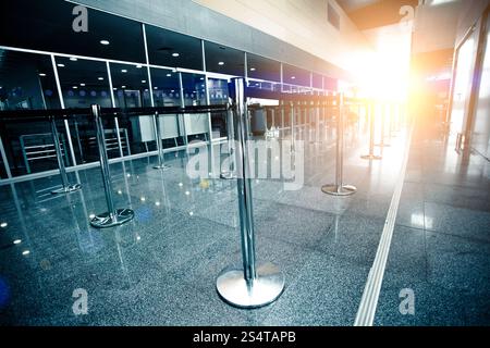 Foto von leeren Flughafen-Check-in-Line beleuchtet von der Sonne Strahl Stockfoto