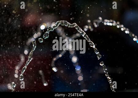 High-Speed-Foto von Lichtbögen Wasser aus Brunnen Stockfoto