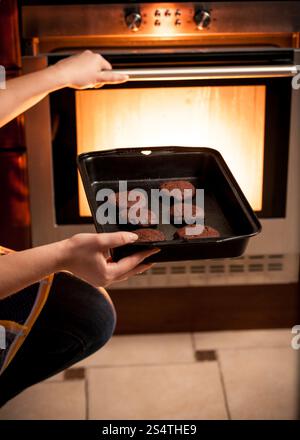 Nahaufnahme Foto Hausfrau mit Cookies Pfanne im Ofen setzen Stockfoto