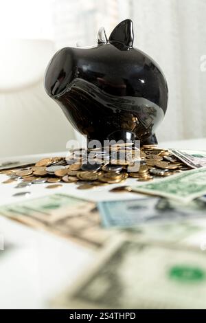 Foto von schwarzen Sparschwein stehend auf Haufen Geld Stockfoto