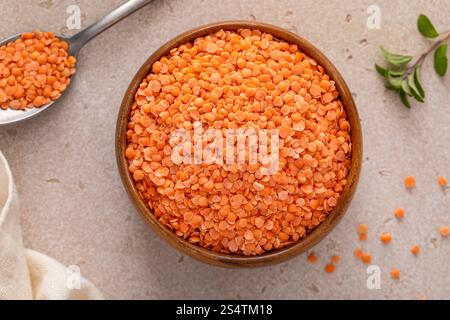 Trockene rote Linsen, bereit zum Kochen in einer Holzschale, vegane Proteinquelle Stockfoto