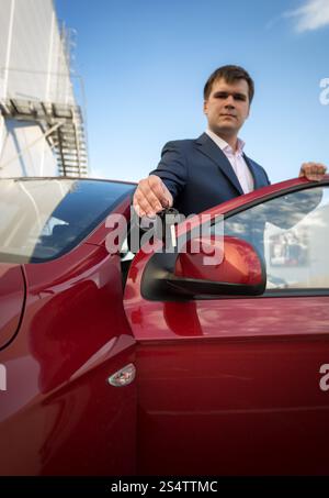 Porträt von glücklich junger Geschäftsmann zeigt neue Autoschlüssel Stockfoto