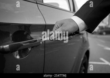 Schwarz / weiß Nahaufnahme Foto des Mannes, die Autoschlüssel in die Bohrung einsetzen Stockfoto