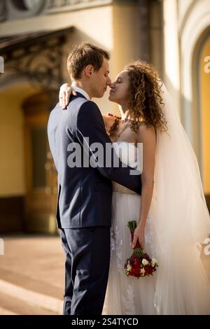 Porträt von Happy, das Brautpaar auf der Straße am sonnigen Tag umschließt Stockfoto