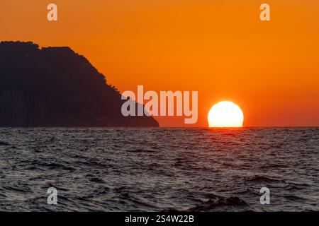 Sonnenuntergang über dem Meer vor der Insel Capri in der Bucht von Neapel, Italien. Stockfoto