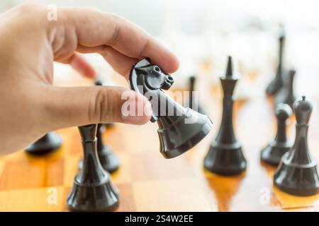 Nahaufnahme Foto von männliche Hand, die Schachfigur schwarzes Pferd Stockfoto