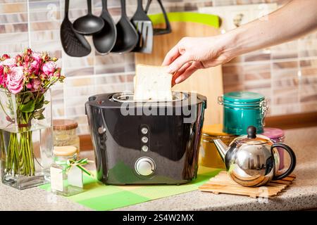 Männliche Hand nehmen gebackene Toast aus dem toaster Stockfoto