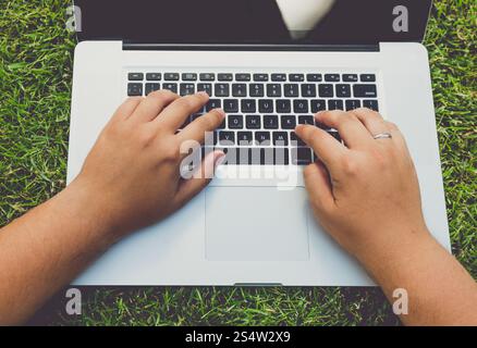 Getönten Foto des Mannes auf dem Rasen liegen und mit laptop Stockfoto
