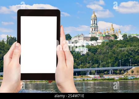 Reisekonzept - Touristenfotografie am Fluss von Kiew Petschersk Lavra, Kiew, Ukraine auf Tablet-pc mit ausgeschnittenem Bildschirm mit leerem Platz für Stockfoto