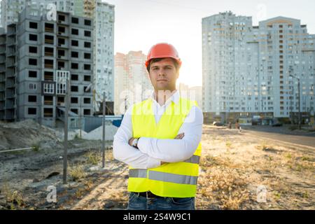 Closeup Portrait eines Ingenieurs in Bauarbeiterhelm posieren gegen Gebäude im Bau Stockfoto
