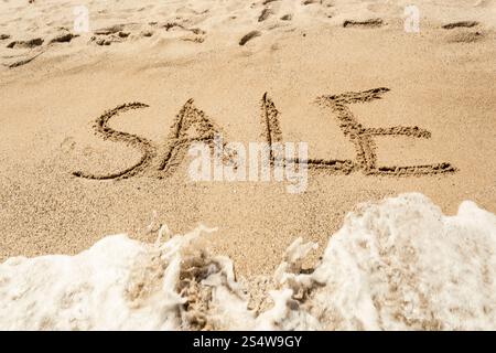 Konzeptionelle Schuss des Wortes abgewaschen Verkauf handschriftlich auf Sand und Wellen Stockfoto