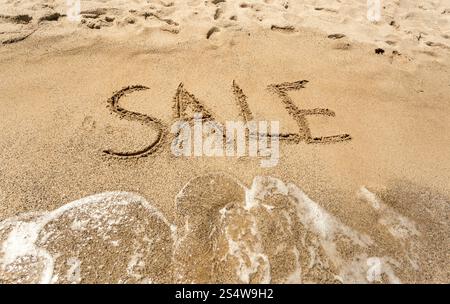 Konzeptionelle Schuss von Verkauf geschrieben am Sandstrand Stockfoto