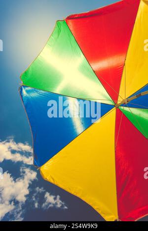 Getönten Foto von bunten Regenschirm gegen blauen Himmel Stockfoto