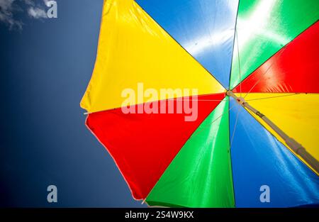 Closeup Aufnahme von bunten Sonnenschirm am Strand gegen blauen Himmel Stockfoto