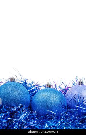 drei blaue Weihnachtskugeln auf Lametta Nahaufnahme isoliert auf weißem Hintergrund Stockfoto