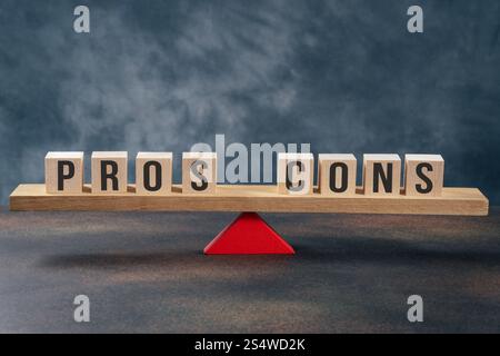 Vor- und Nachteile balancieren auf einer hölzernen Wippe auf grauem Hintergrund Stockfoto