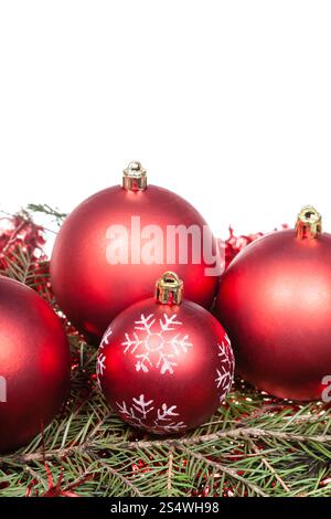 roter Weihnachtsschmuck auf grüne Fichte Baum Zweig isoliert auf weißem Hintergrund Stockfoto