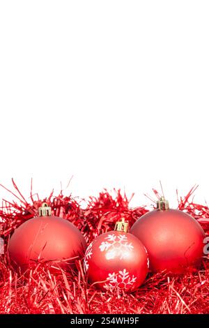 drei rote Christbaumkugeln und Lametta isoliert auf weißem Hintergrund Stockfoto
