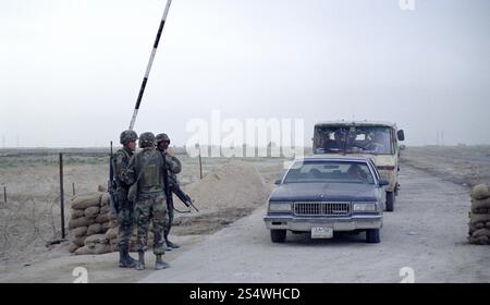 Erster Golfkrieg: 21. März 1991 der irakische Verkehr wartet auf die Überquerung des Checkpoint Charlie, der Grenze der Besetzung durch die US-Armee entlang des Highway 8, 8 km südlich von Nasiriyah im südlichen Irak. Stockfoto