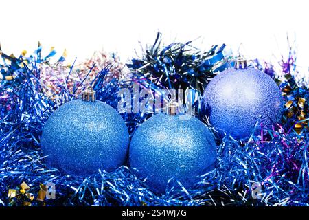 drei blaue Christbaumkugeln und Lametta isoliert auf weißem Hintergrund Stockfoto
