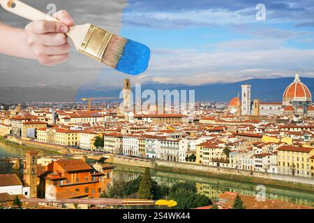 Reisekonzept - Hand mit Pinsel malt blauen Himmel über der Stadt Florenz, Italien Stockfoto