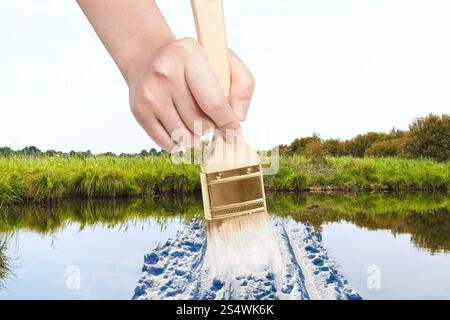 Natur-Konzept - Jahreszeiten und Wetter ändert - Hand mit Pinsel malt Schnee Weg im Sumpf im Sommer Stockfoto