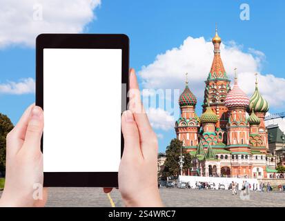 Travel Concept - Hand hält tablet pc mit ausgeschnittenen und Pokrovsky Kathedrale auf dem Roten Platz in Moskau im Hintergrund Stockfoto
